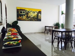 A dining area with a long table, chairs, and a painting on the wall. - Terrace Villa Hoi An (Da Nang)
