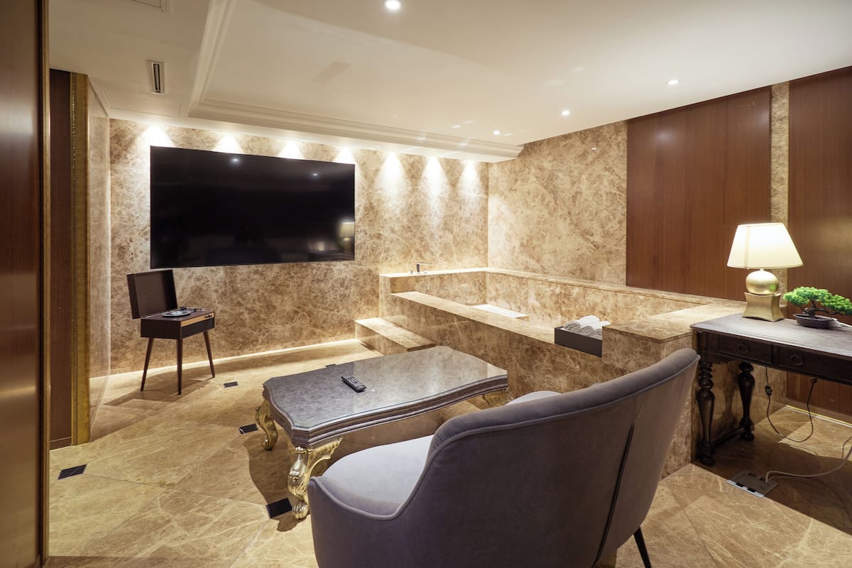 A modern bathroom with a large mirror, a sink, and a toilet.