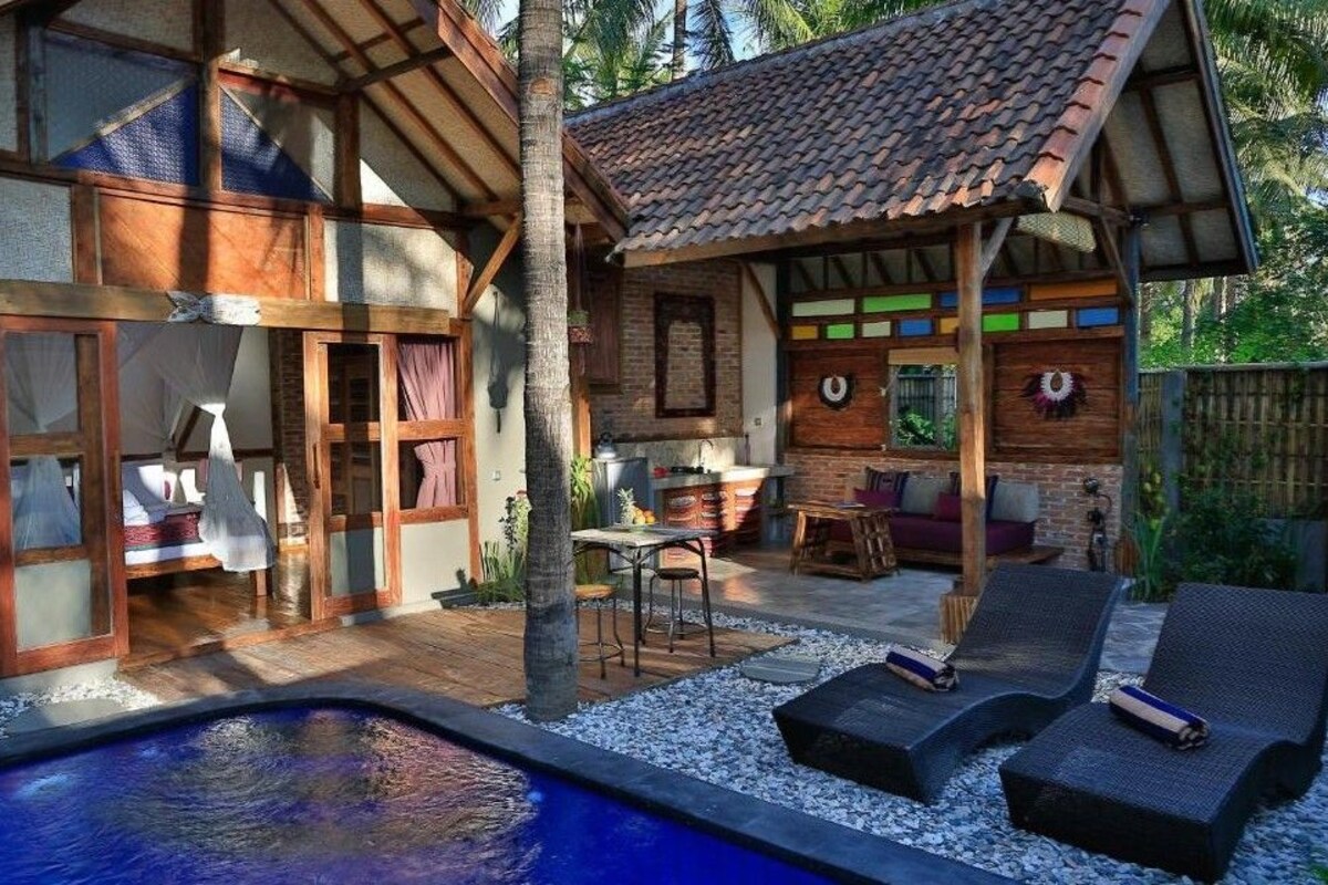 Una casa con piscina, mobiliario de exterior y un patio cubierto.