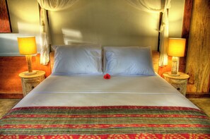 A neatly made bed with white linens, two bedside lamps, and a decorative red flower. - Villas Samalama Gili Trawangan (Gili Trawangan)