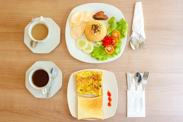 A breakfast plate with toast, a cup of coffee, and a plate of eggs and vegetables. - LeGreen Suite Waihaong (Ambon)