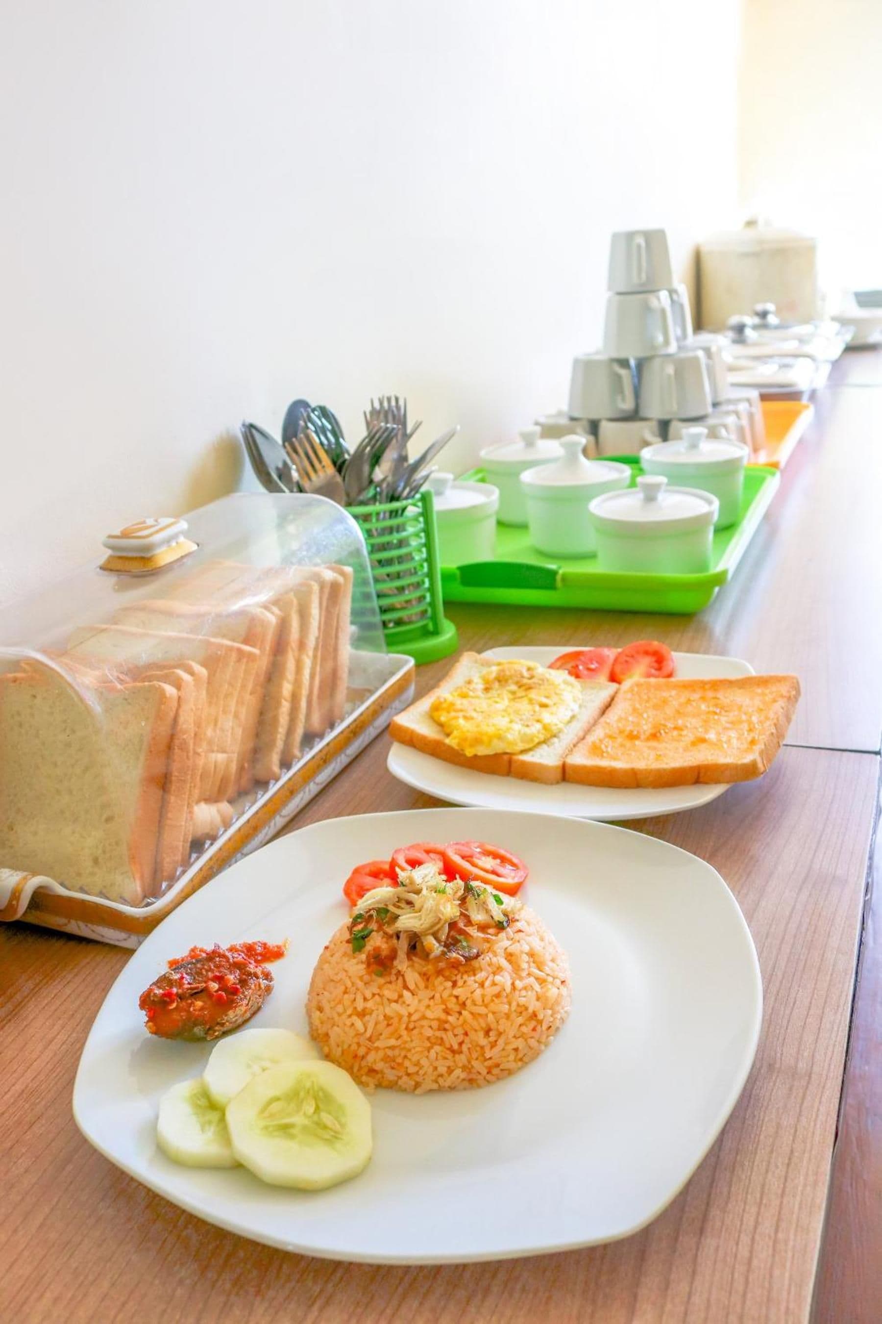 A breakfast buffet with various food items and utensils.