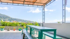 Un espacio al aire libre cubierto con bancos verdes y plantas en macetas.