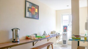 Una cocina con una encimera larga, una cafetera y un refrigerador.