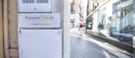 A sign for 'StayinToledo' with a label '2º Piano Scala A' on a building facade.