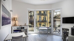 Un appartement moderne comprenant un coin repas, une cuisine et un balcon offrant une vue sur la ville.