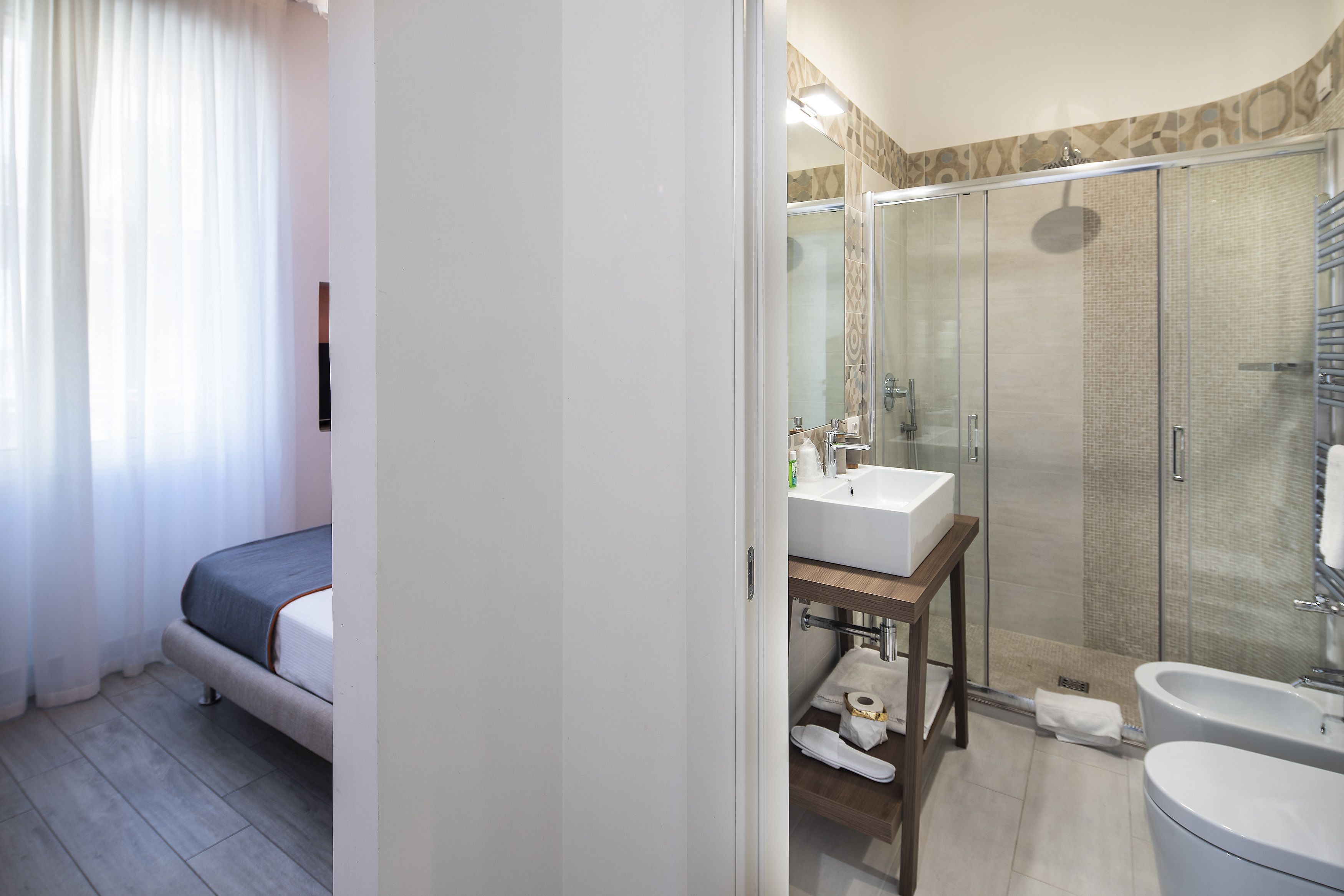 A modern bathroom with a glass-enclosed shower, a white sink, and a separate bathtub.