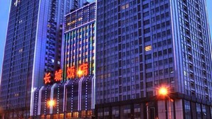 Dos edificios altos con un cartel iluminado grande al frente.