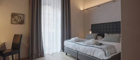 A modern bedroom with a bed, a chair, and a large window with curtains.