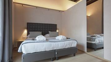 Un dormitorio moderno con una cama grande, mesitas de noche y un espejo.