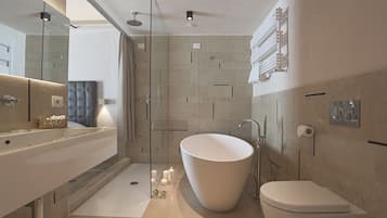 A modern bathroom with a freestanding bathtub, a glass-enclosed shower, and a large mirror.