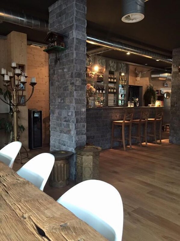 Un rústico espacio de bar con muebles de madera y paredes de piedra.