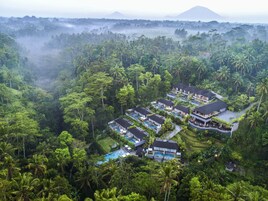 A resort with multiple villas, a swimming pool, and lush tropical surroundings.