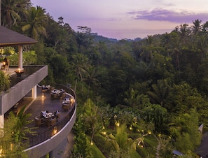 A resort with a curved deck, outdoor seating, and lush tropical vegetation. - Samsara Ubud (Payangan)