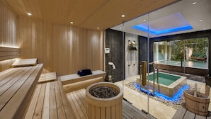 A modern spa with wooden floors, a sauna, a glass-enclosed hot tub, and a view of a garden. - Samsara Ubud (Payangan)