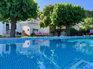 A clear blue swimming pool with tiled edges, surrounded by lounge chairs and a small building. - B&B Wine and Cooking Penedès (El Pla del Penedes)