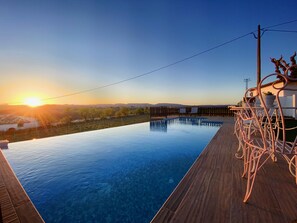 Una piscina al aire libre, sillones reclinables de piscina