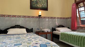 Habitación de hotel con dos camas, un cuadro en la pared, una ventana con cortinas y un cabecero de azulejos.