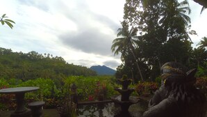 A garden with a statue, a pond, and a view of a mountain. - Pondok Batur Indah (Karangasem)