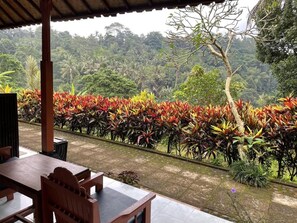 An outdoor seating area with a view of a lush, tropical landscape. - Pondok Batur Indah (Karangasem)