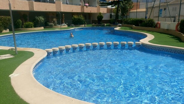 Uma piscina grande e translúcida, com borda curva e detalhes padronizados.