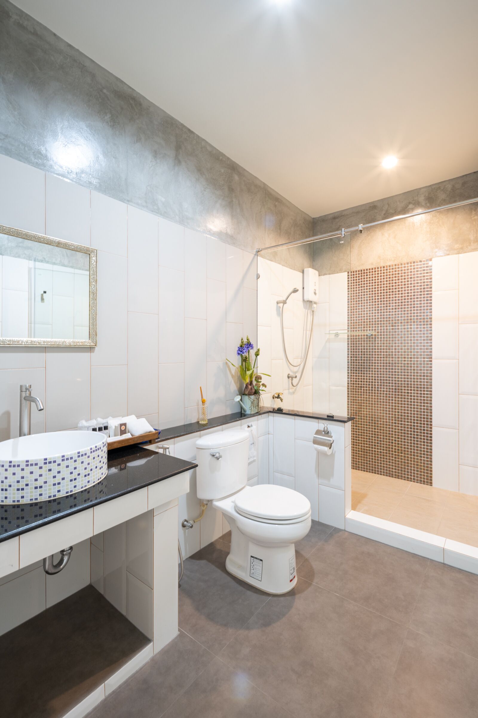 Un baño moderno con un lavamanos grande, inodoro y zona de ducha.
