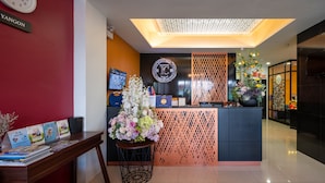 A reception desk with a clock, a floral arrangement, and a sign with the letters "IC".