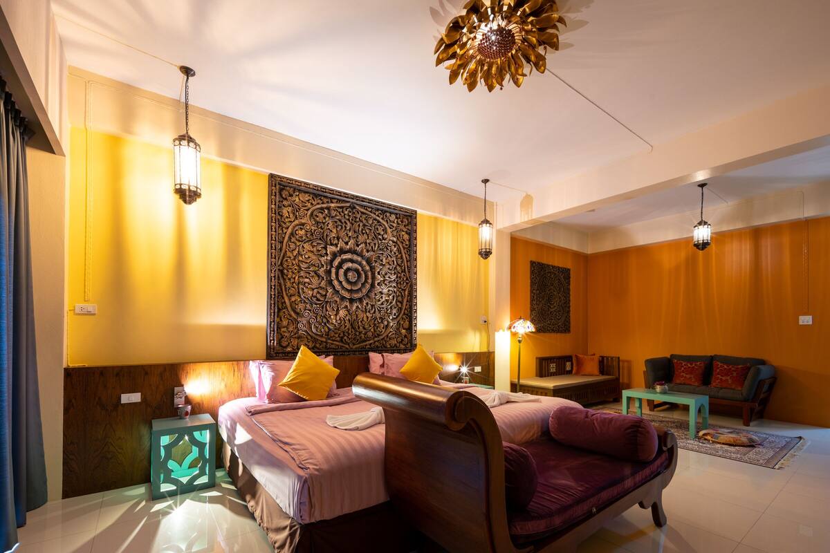 Una habitación de hotel con dos camas, un sofá, una mesita de café y un adorno en la pared.