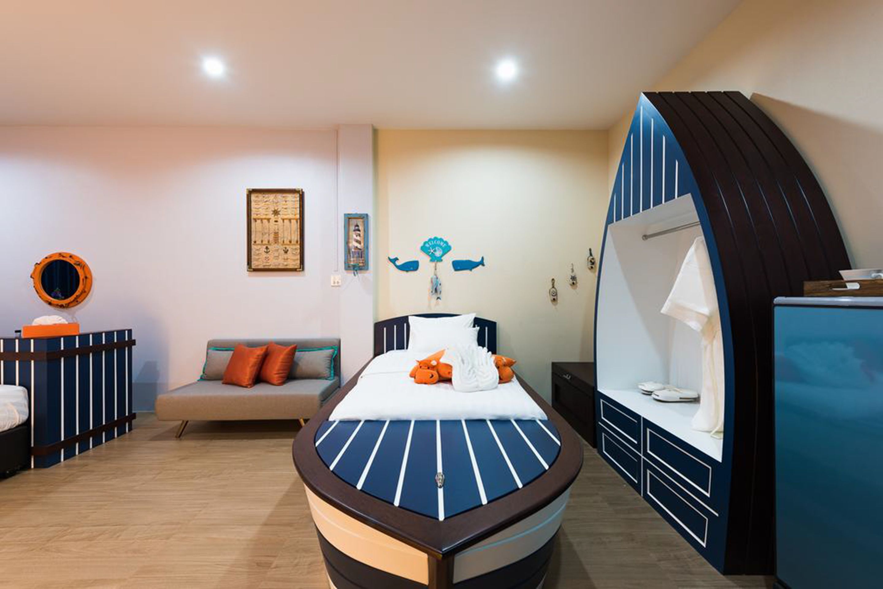 Una habitación de hotel moderna con una cama grande, un sofá, un escritorio y una zona de estar curvada.