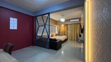 A modern hotel room with a bed, a desk, and a partition.