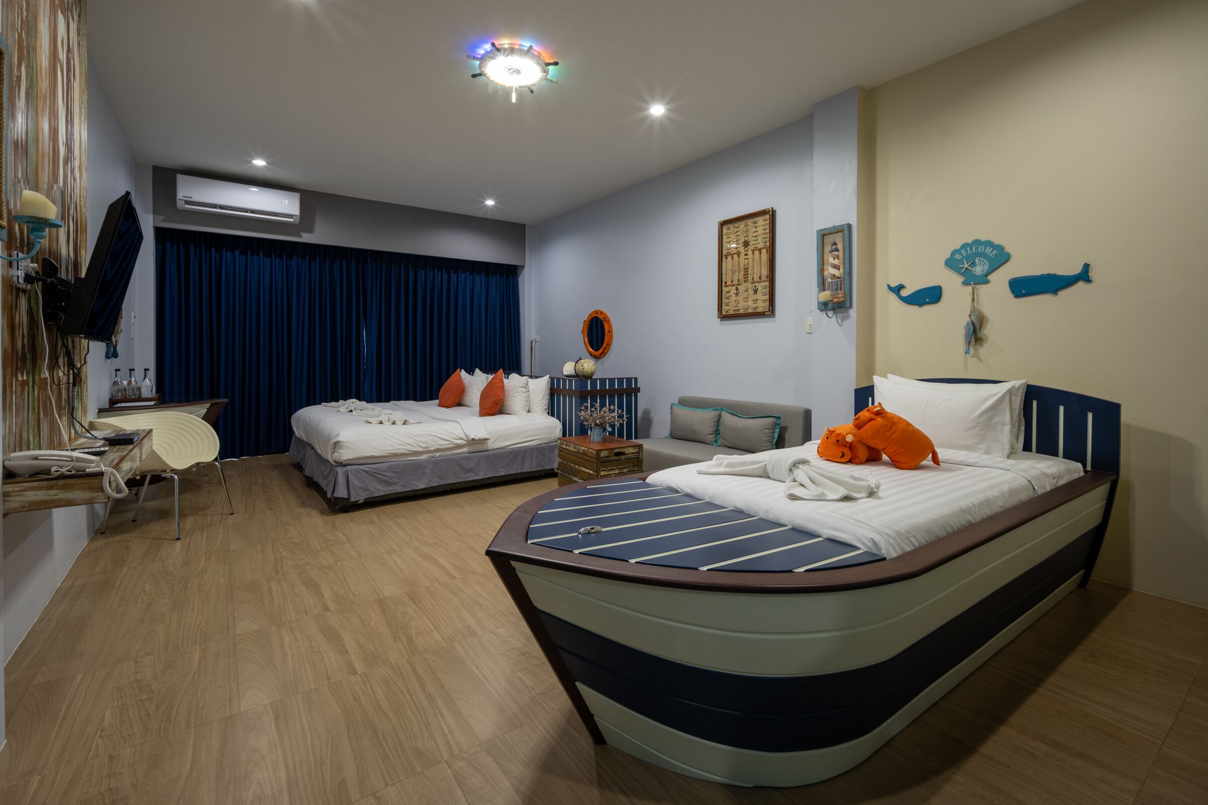 A hotel room with two beds, a desk, and a chair.