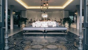 Un dormitorio amplio con una cama grande, un candelabro y un papel tapiz estampado.