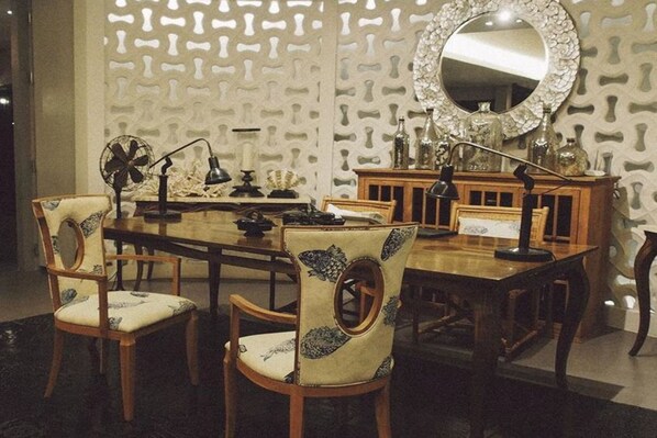 A dining area with a wooden table, chairs, and a decorative mirror.