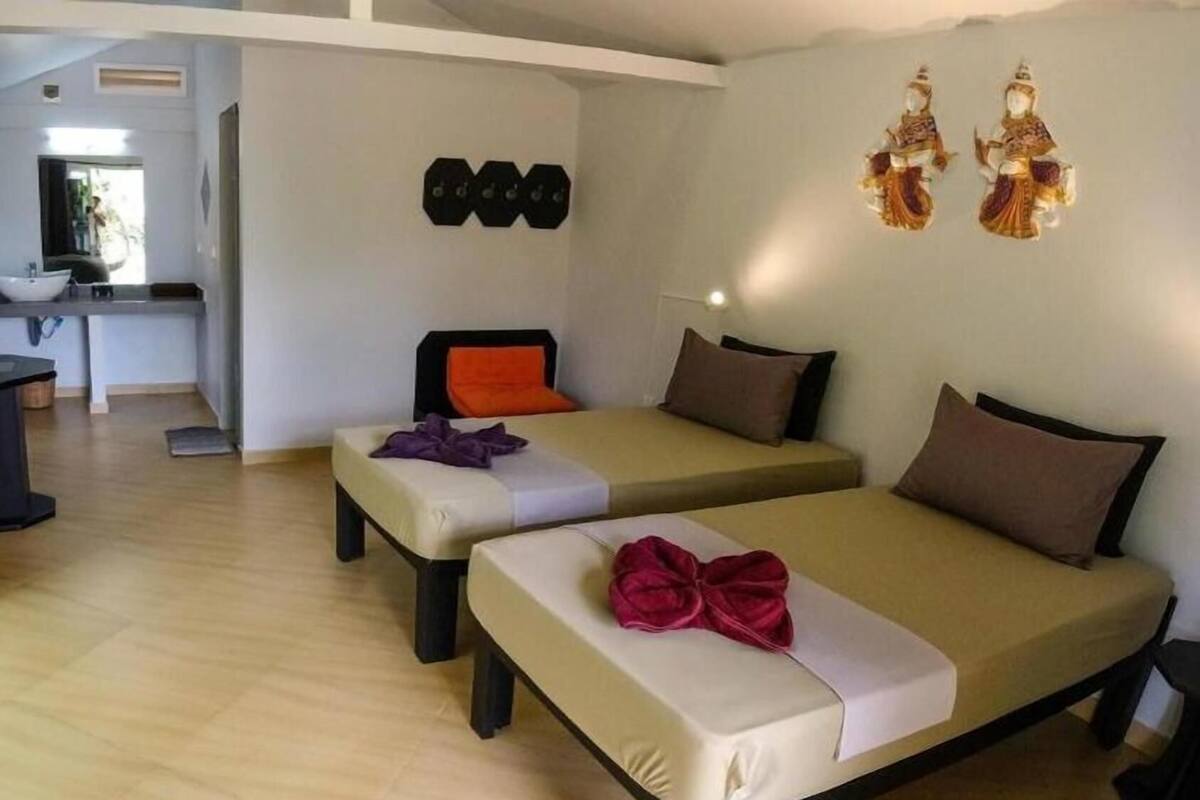Ein Zimmer mit zwei Betten, einem kleinen Schreibtisch und einer Wanddekoration.
