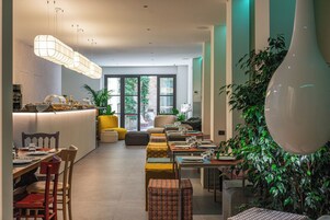Un interior moderno con comedor, cocina y zona de estar con una planta grande.