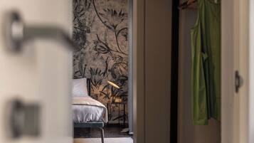 Un dormitorio con cama, mesita de noche y pared con estampado floral.