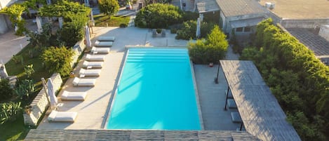 Ein Pool auf dem Dach mit Liegestühlen und einer Holzterrasse.