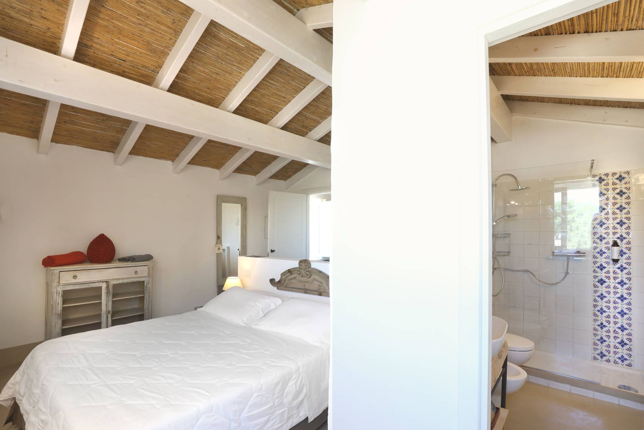 Une chambre à coucher comprenant un lit, une commode et une salle de bain avec douche et toilettes.