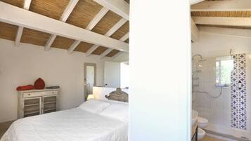 Une chambre à coucher comprenant un lit, une commode et une salle de bain avec douche et toilettes.