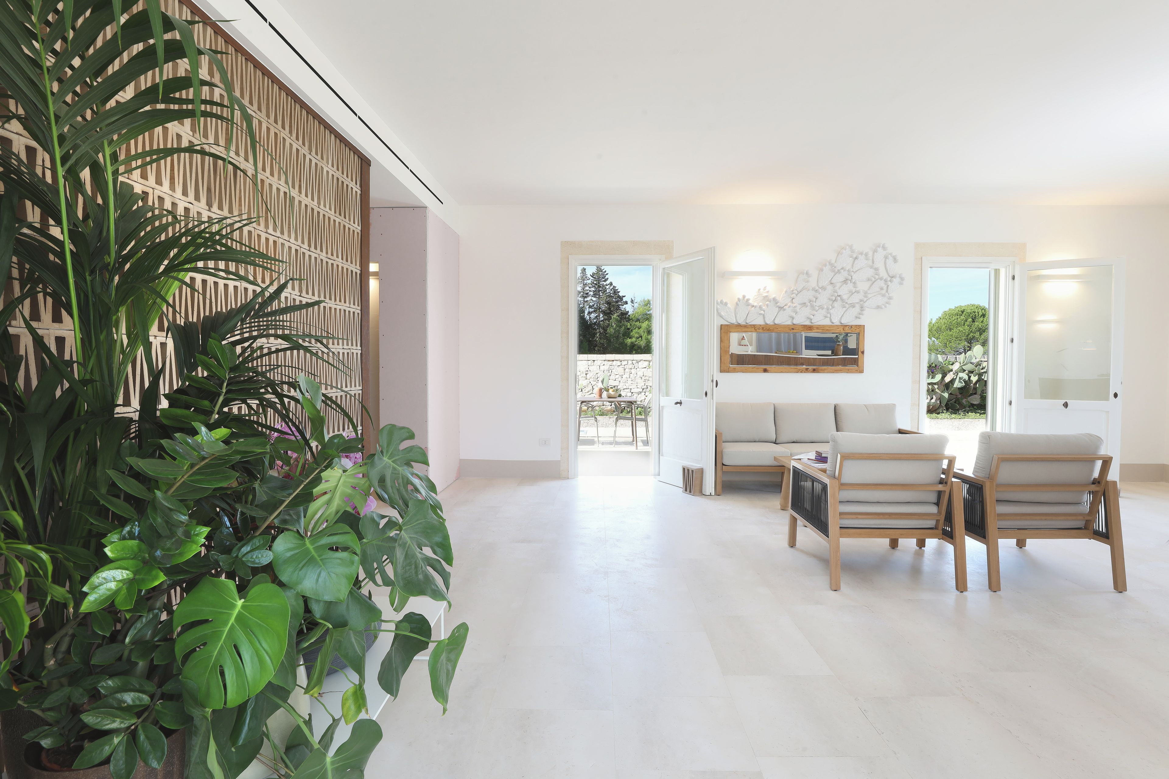 A modern living room with a large potted plant, a sofa, and a coffee table.