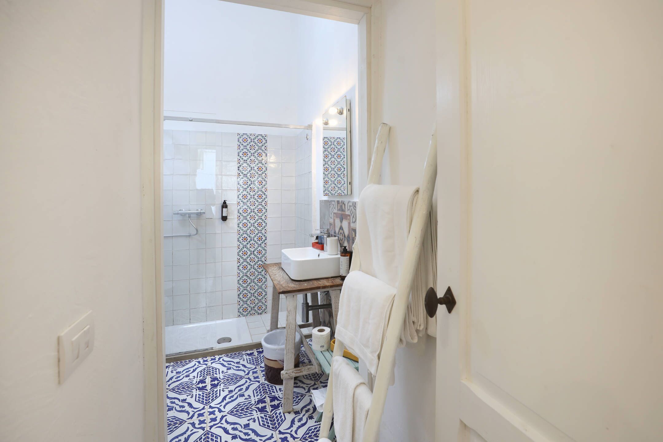 A bathroom with a shower, a sink, a toilet, and a towel rack.