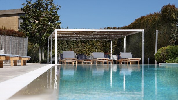 A clear swimming pool with lounge chairs and a covered seating area. - Salento Residence & Suite (Lecce)
