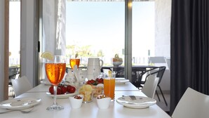 A dining table with a glass of orange juice, a glass of red wine, and various snacks. - Salento Residence & Suite (Lecce)