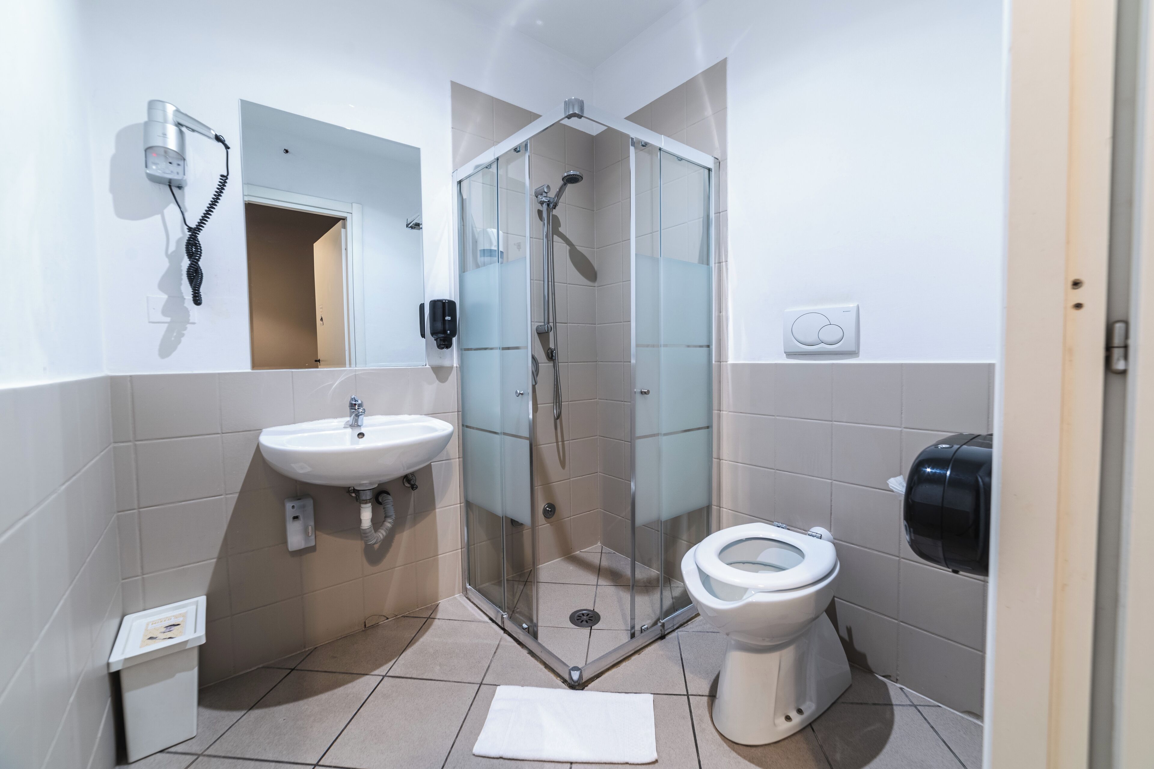 A modern bathroom with a glass-enclosed shower, a sink, and a toilet.