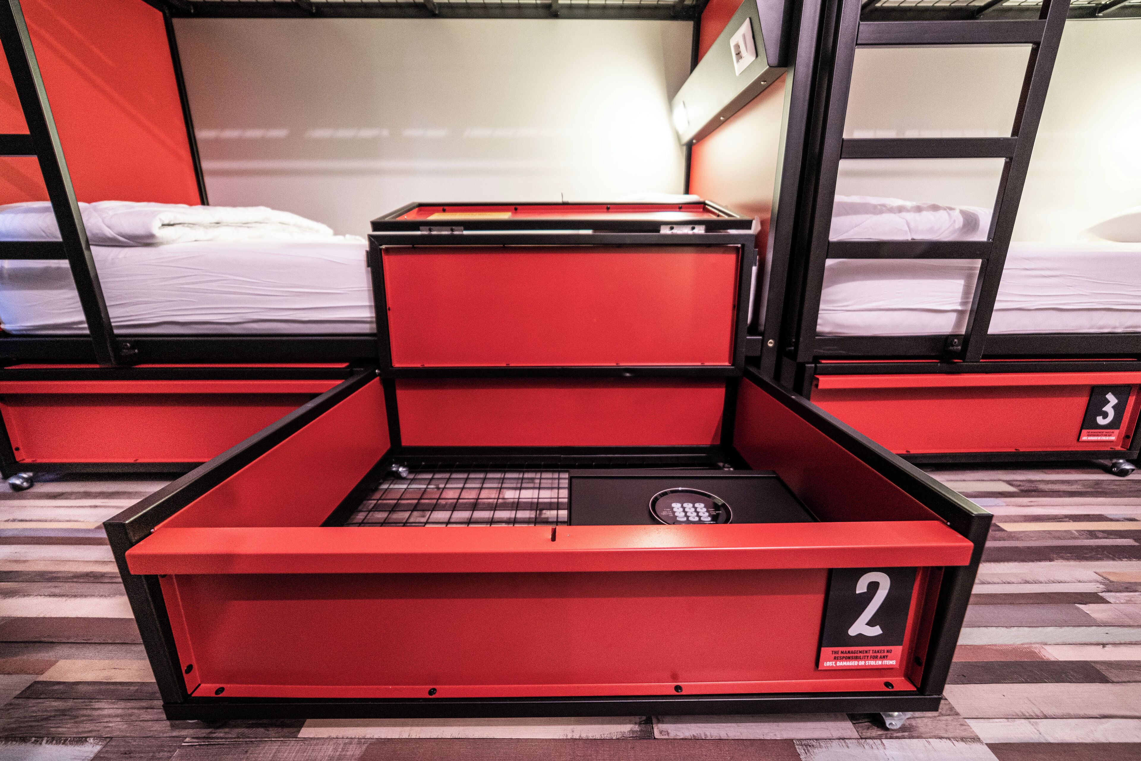 A bunk bed room with a red storage unit labeled '2' in the center.