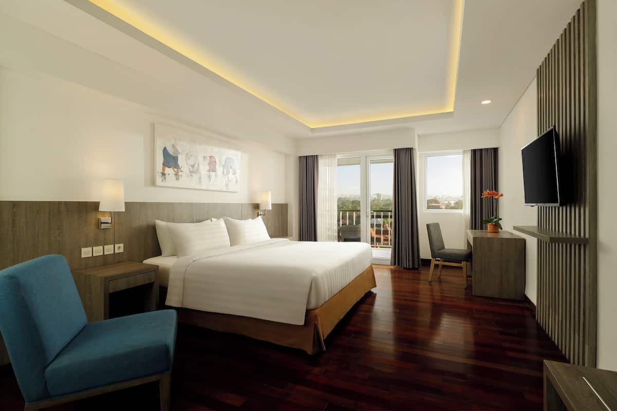 Une chambre d’hôtel moderne dotée d’un grand lit, d’un bureau, d’une télévision et offrant une vue sur l’extérieur.