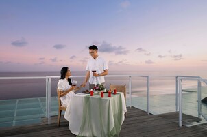 A couple dining at a table with a view of the ocean.