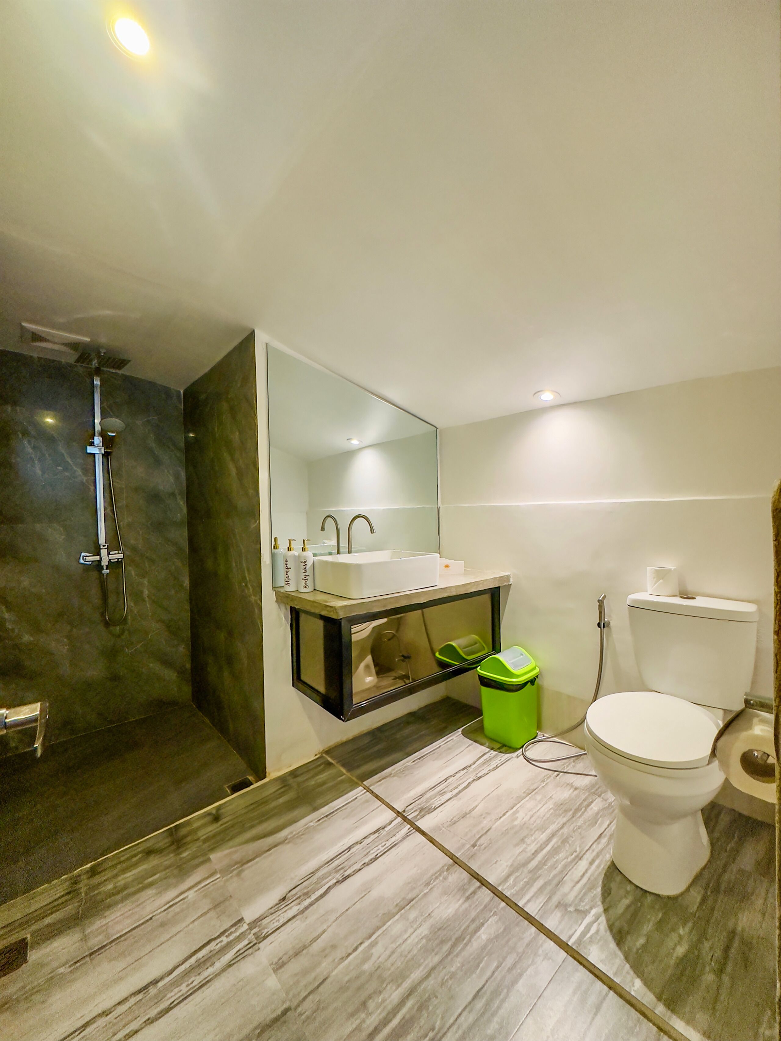 A modern bathroom with a shower, sink, and toilet.