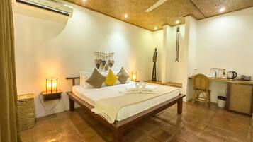 A spacious bedroom with a large bed, a desk, and a ceiling fan.