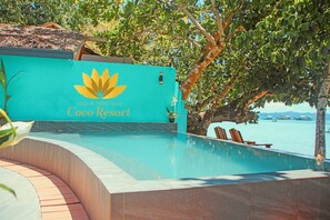 Una piscina al aire libre, sillones reclinables de piscina
